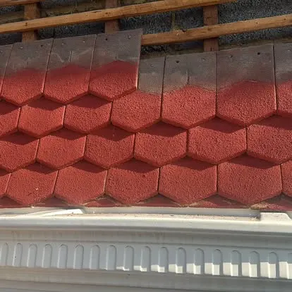 Close-up of red tiled roof panels above a white fascia board